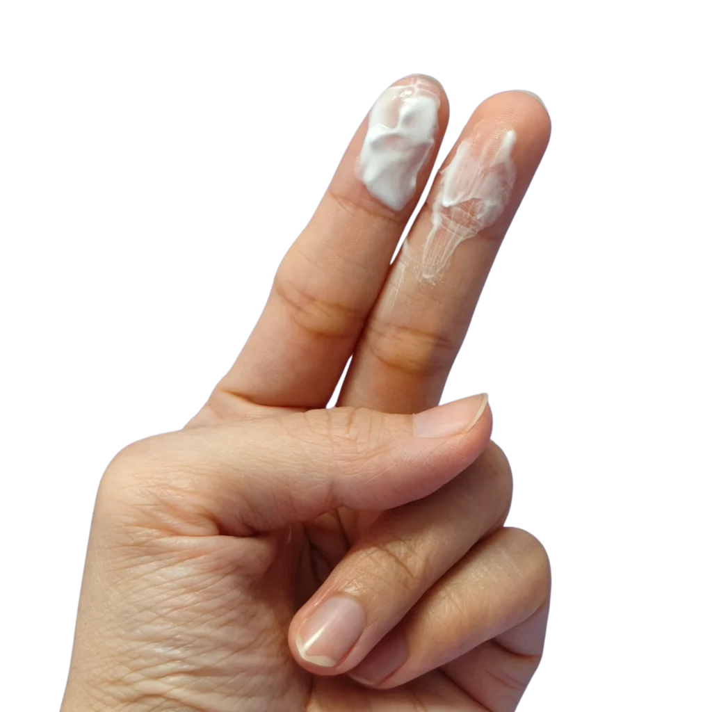 Nahaufnahme einer Hand mit zwei ausgestreckten Fingern, an denen weißlicher, cremiger Zervixschleim haftet.