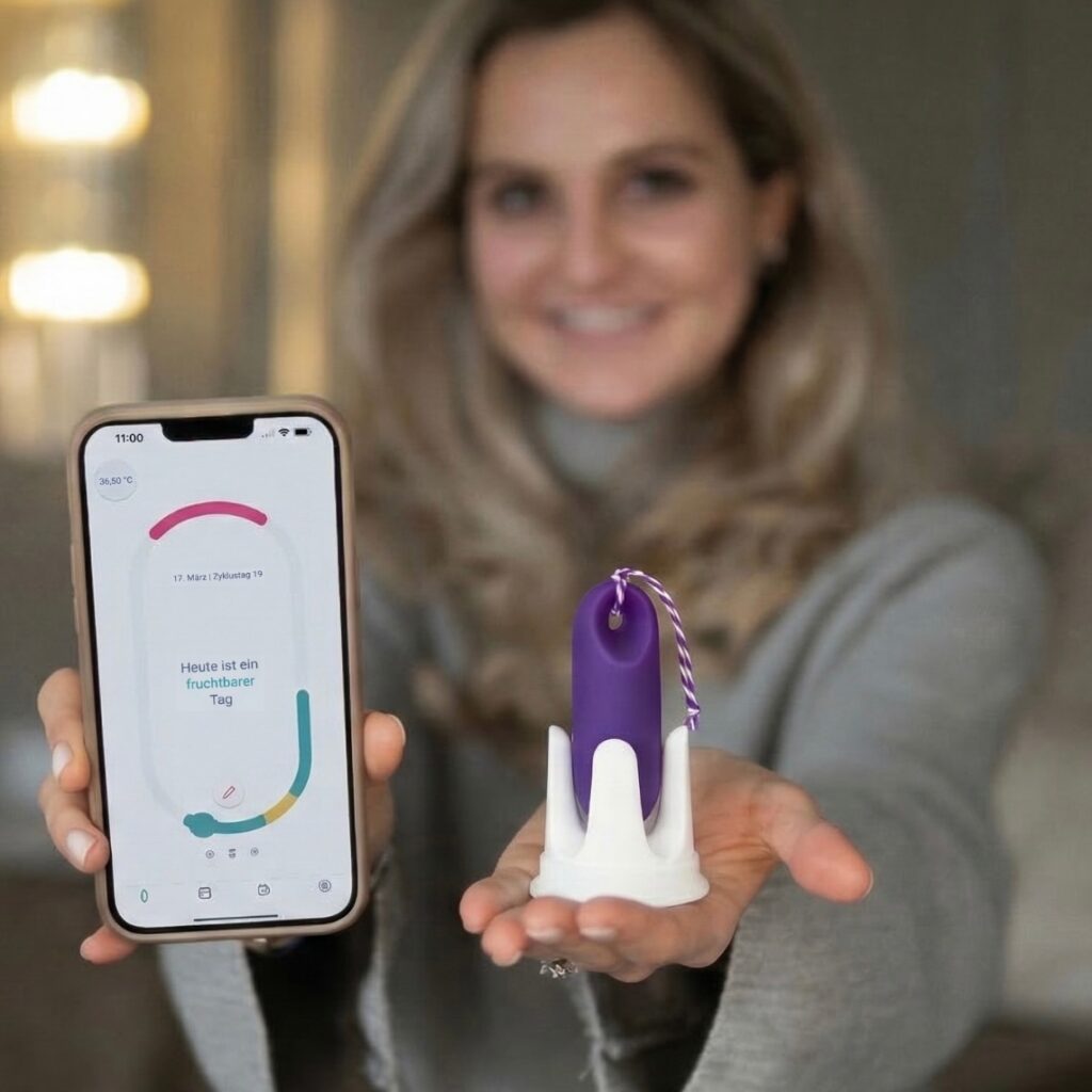 Frau zeigt die tarckle App und den Sensor