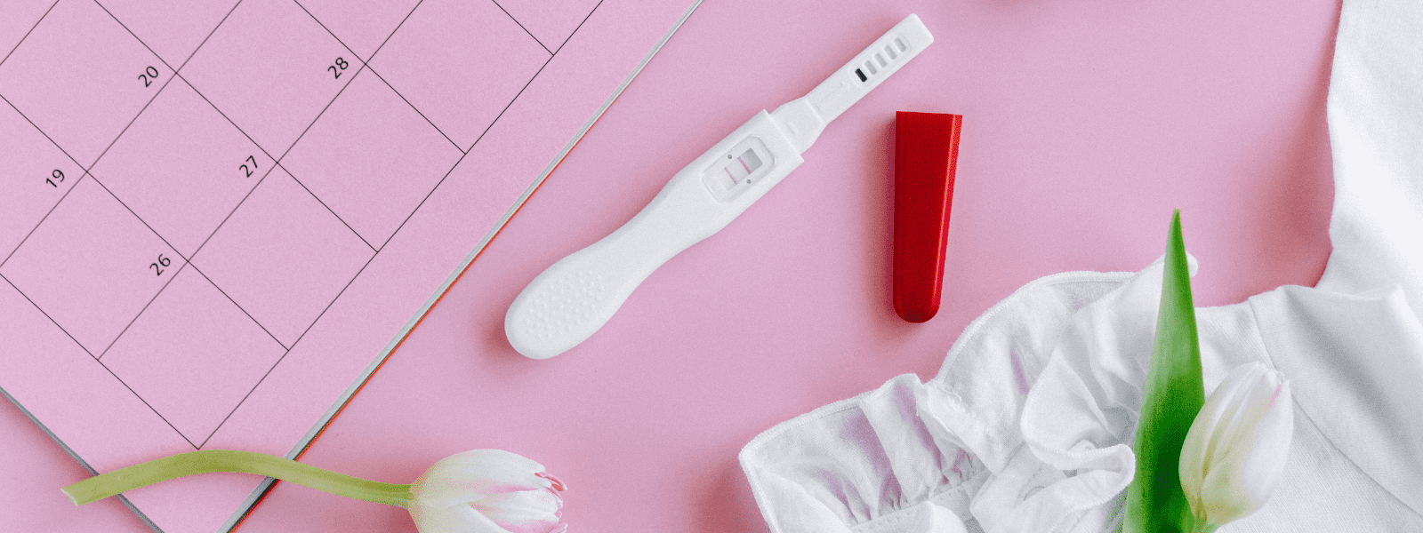 Foto von einem Schwangerschaftstest vor einem rosa Hintergrund.